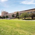 UQ's Forgan Smith building with green lawn in the foreground.